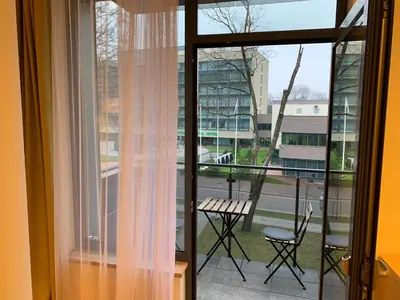 a room with a window with a table and chairs at Brolių studija in Druskininkai