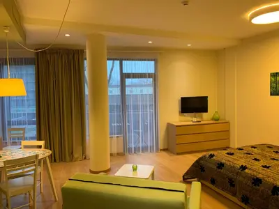 a bedroom with a bed and a table and a television at Brolių studija in Druskininkai