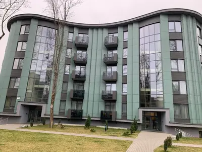 an office building with a green facade at Brolių studija in Druskininkai