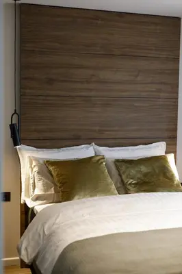 a bedroom with a large bed with a wooden headboard at City Center Apartment in Siauliai in Šiauliai