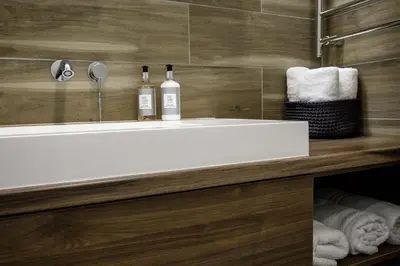 a bathroom with a sink with two bottles on it at City Center Apartment in Siauliai in Šiauliai