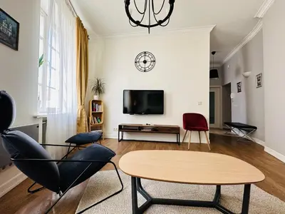a living room with a table and chairs and a tv at Very Vilnius Stikliu street in Vilnius