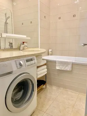 a bathroom with a washing machine and a bath tub at Very Vilnius Stikliu street in Vilnius