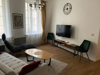 a living room with a couch and a tv at Very Vilnius Stikliu street in Vilnius