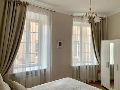 a bedroom with a bed and two windows at Very Vilnius Stikliu street in Vilnius
