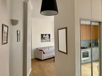a living room with a white couch and a mirror at Very Vilnius Stikliu street in Vilnius