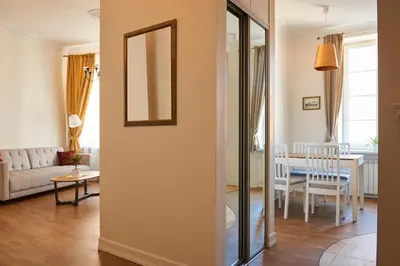 a living room with a table and a mirror at Very Vilnius Stikliu street in Vilnius