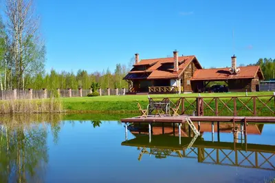 a house sitting on the side of a lake at Skliausčių laisvalaikio centras in Skliausciai