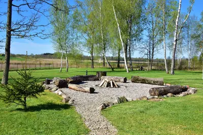 a fire pit in a park with trees and grass at Skliausčių laisvalaikio centras in Skliausciai