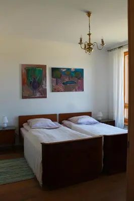 a bedroom with two beds and a chandelier at Ruta Marija in Druskininkai