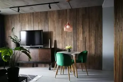 a dining room with a table and green chairs and a tv at ERTA Anykščių Namai in Anykščiai