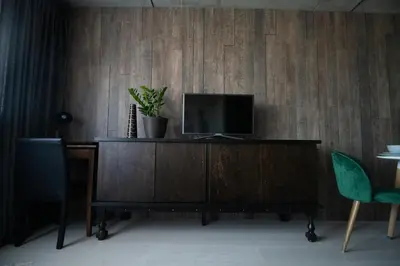 a living room with a tv on a wooden dresser at ERTA Anykščių Namai in Anykščiai