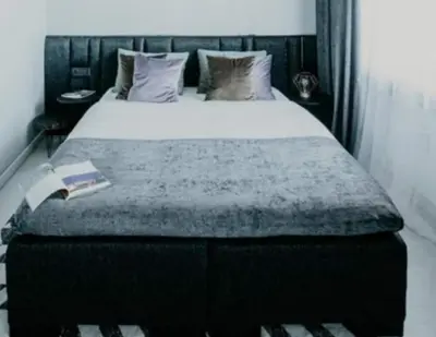 a bedroom with a bed with a book on it at ERTA Anykščių Namai in Anykščiai