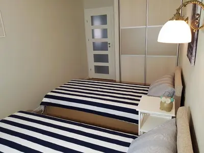 a small bedroom with a bed and a lamp at TIP TOP in Šiauliai