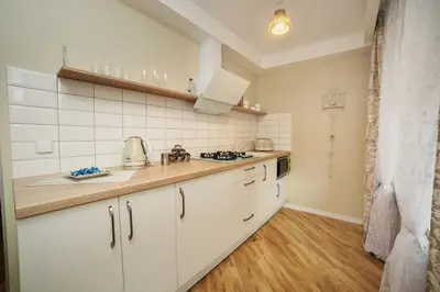 a kitchen with white cabinets and a counter top at TIP TOP in Šiauliai