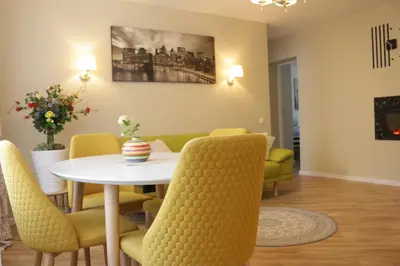 a dining room with a white table and yellow chairs at TIP TOP in Šiauliai