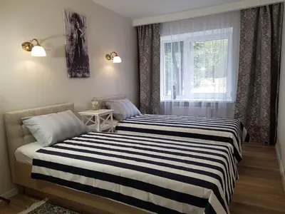 two beds in a room with a window at TIP TOP in Šiauliai