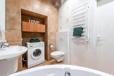 a bathroom with a sink and a washing machine at Angel House Vilnius, Dysnos in Vilnius
