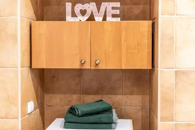 a pile of green towels sitting on a shelf in a bathroom at Angel House Vilnius, Dysnos in Vilnius