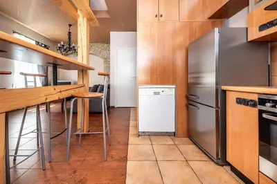 a kitchen with stainless steel appliances and wooden cabinets at Angel House Vilnius, Dysnos in Vilnius