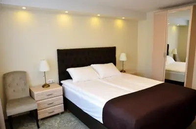 a bedroom with a bed and a chair and a mirror at Pasažo namai B&B in Raseiniai