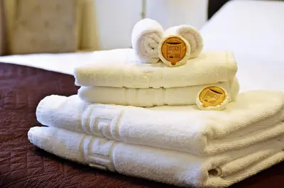 a pile of towels sitting on top of a bed at Pasažo namai B&B in Raseiniai