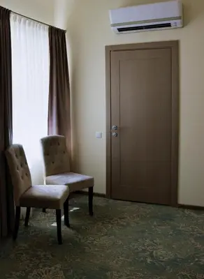 a room with two chairs and a door and a window at Pasažo namai B&B in Raseiniai