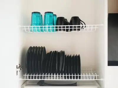 a shelf filled with black plates and blue dishes at Black & White Studio in Anykščiai