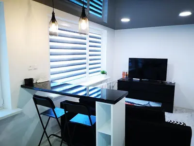 a dining room with a glass table and chairs at Black & White Studio in Anykščiai