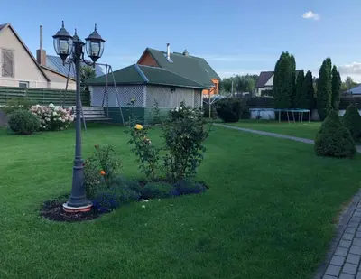 a lamp post in a yard next to a house at Arvydo Gylio sodyba in Ignalina