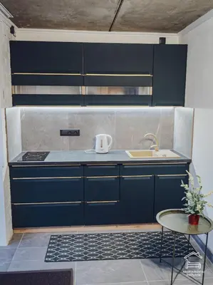 a kitchen with blue cabinets and a sink and a table at Apartamentai Biržuose, cozy garage in Biržai