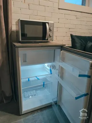 an open refrigerator with a microwave on top of it at Apartamentai Biržuose, cozy garage in Biržai