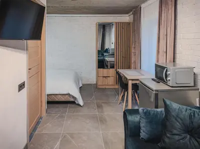 a room with a bed and a desk with a tv at Apartamentai Biržuose, cozy garage in Biržai