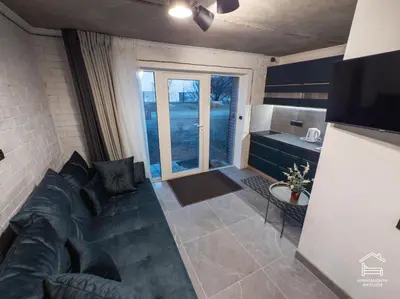 a living room with a couch and a kitchen at Apartamentai Biržuose, cozy garage in Biržai