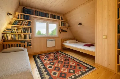a small attic room with two beds and a window at Miguičionių sodyba in Migučionys