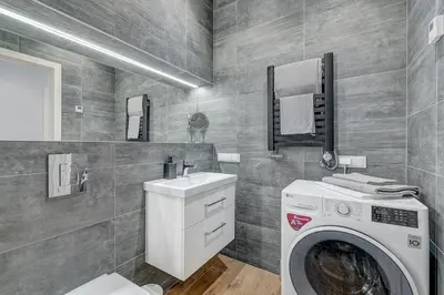 a bathroom with a washing machine and a sink at HaPPy Inn Emporia, Self chek-in, Parking in the underground garage in Vilnius