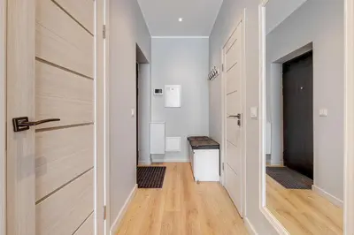 a hallway with a wooden door and a hallway with a table at HaPPy Inn Emporia, Self chek-in, Parking in the underground garage in Vilnius