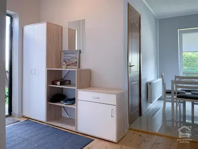 a room with a white cabinet and a table at Apartamentai Biržuose, double bedroom and single bedroom Apartments in Biržai