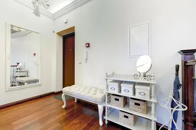 a white room with a bench and a mirror at Old Town Gate Residence in Vilnius