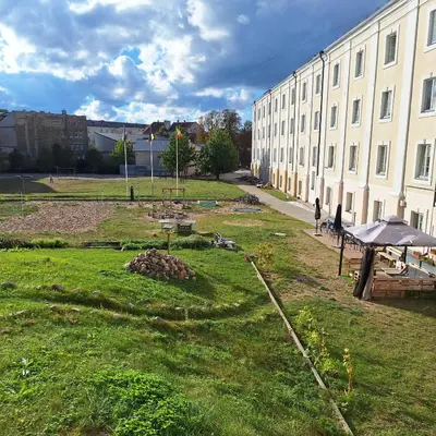 a large building with a grass yard next to a building at Old Town Gate Residence in Vilnius