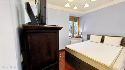 a bedroom with a bed and a wooden cabinet at Old Town Gate Residence in Vilnius