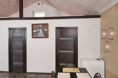 a room with two doors and a table and a sink at Smėlio Apartamentai in Anykščiai