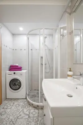 a white bathroom with a washing machine and a sink at A. Vienuolio gatvė Apartamentai in Vilnius