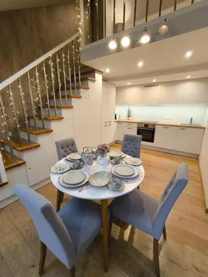 a dining room with a table and blue chairs at A. Vienuolio gatvė Apartamentai in Vilnius