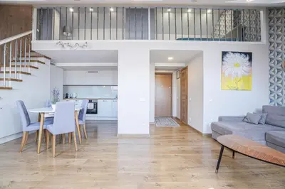 a living room and kitchen with a couch and a table at A. Vienuolio gatvė Apartamentai in Vilnius