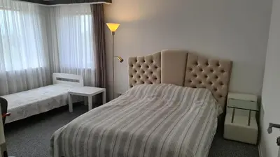 a hotel room with a bed and a lamp and window at Sofia apartments, 6 rooms, 260m2 in Vilnius