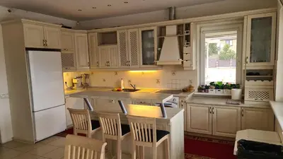 a kitchen with white cabinets and a kitchen island with chairs at Sofia apartments, 6 rooms, 260m2 in Vilnius