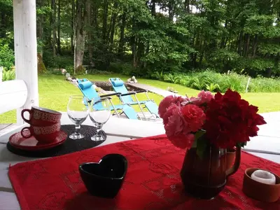 a table with a vase of flowers on a red table cloth at White homestead in Sumiliszki