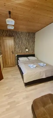 a bedroom with a large bed and a wooden ceiling at Apartamentai pas Danutę in Prienai