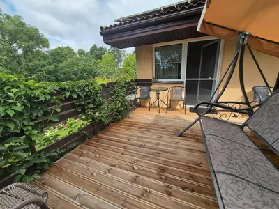 a deck with a table and chairs on a house at Apartamentai pas Danutę in Prienai